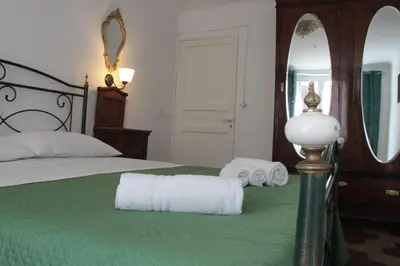 a bedroom with a bed with two towels and a mirror at La Giara in Palermo