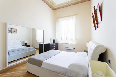 a bedroom with a bed and a large mirror at Quattro canti luxury apartment in Palermo