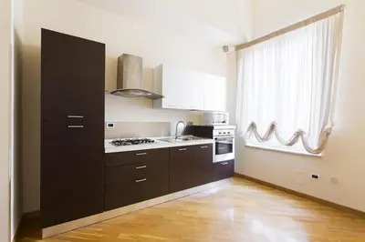 a kitchen with black cabinets and a stove and a window at Quattro canti luxury apartment in Palermo