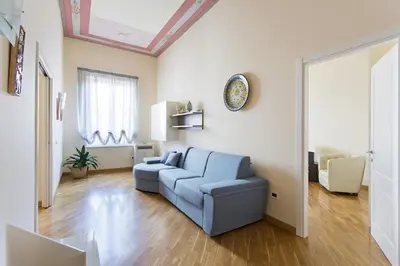 a living room with a blue couch and a window at Quattro canti luxury apartment in Palermo