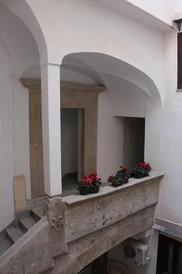 a building with two potted plants on a ledge at Sant'Andrea - Luxury Rooms in Vucciria in Palermo