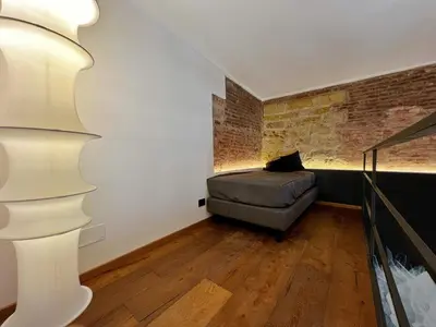 a bedroom with a bed and a brick wall at Sant'Andrea - Luxury Rooms in Vucciria in Palermo