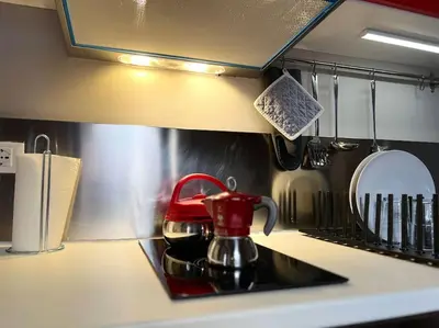 a red tea kettle sitting on a stove in a kitchen at 38,VELASQUEZ in Palermo