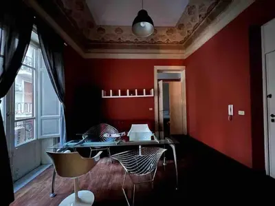 a red room with a table and chairs at 38,VELASQUEZ in Palermo