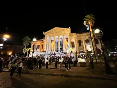 a group of people standing in front of a building at night at 38,VELASQUEZ in Palermo