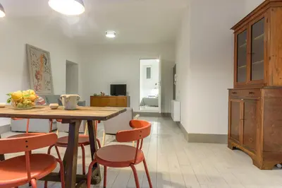 a dining room with a wooden table and orange chairs at Suite Gharraf Palermo Old Town in Palermo