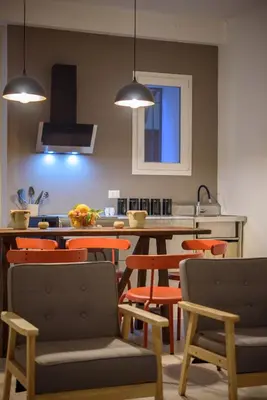 a kitchen with orange chairs and a kitchen table at Suite Gharraf Palermo Old Town in Palermo