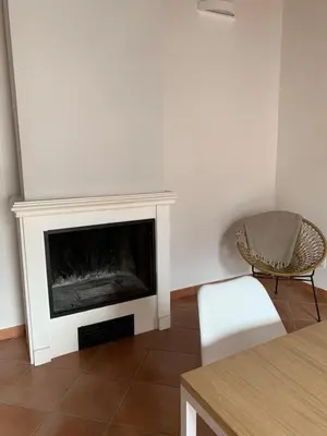 a living room with a fireplace and a chair at Palazzo resuttana in Palermo