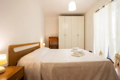 a bedroom with a white bed with towels on it at Hola House al Capo in Palermo