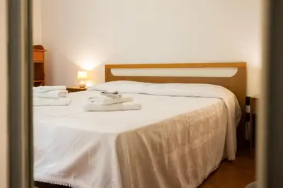 a bedroom with a white bed with towels on it at Hola House al Capo in Palermo
