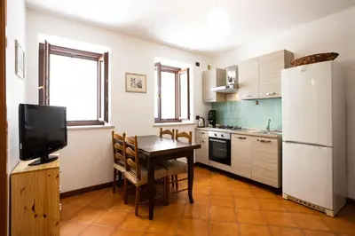 a small kitchen with a table and a refrigerator at Hola House al Capo in Palermo