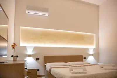 a bedroom with two beds and a large window at Piave77 in Bagheria