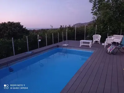 a swimming pool on a deck with a table and chairs at Holiday Homes in Campofelice di Roccella