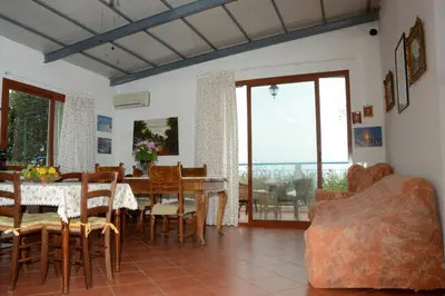 a dining room with a table and chairs with a view at Holiday Homes in Campofelice di Roccella