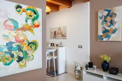 a living room with a large painting on the wall at Suite San Sebastiano by DomuSicily in Palermo