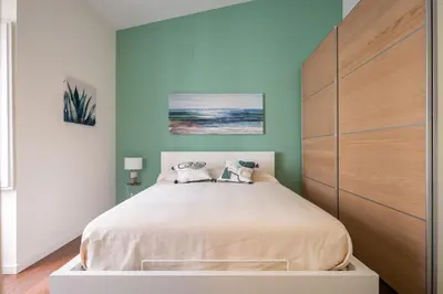 a bedroom with a large bed with a wooden headboard at Suite San Sebastiano by DomuSicily in Palermo