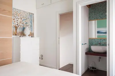 a bedroom with a bathroom with a sink at Suite San Sebastiano by DomuSicily in Palermo