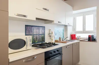 a kitchen with a microwave and a stove top oven at Suite San Sebastiano by DomuSicily in Palermo