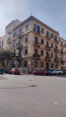 a large building with cars parked in front of it at Himera Holiday in Palermo