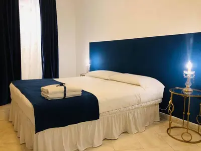 a bedroom with a large bed with a blue wall at B&B Al Piazza Marina in Palermo