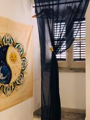 a window with a curtain and a picture of a sun at B&B Al Piazza Marina in Palermo