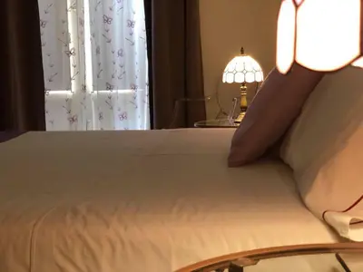 a bedroom with a bed with a lamp and a window at B&B Al Piazza Marina in Palermo