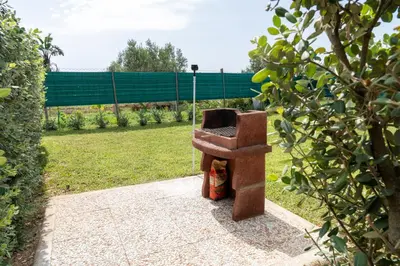 a chair sitting on a sidewalk in a garden at Garden Voyages Balestrate in Balestrate