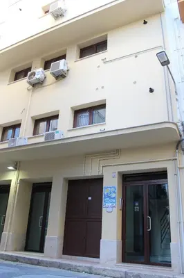 a building with two garage doors and windows at Ideal Residence & SPA in Alcamo