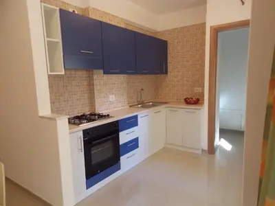 a small kitchen with blue cabinets and a sink at Ideal Residence & SPA in Alcamo