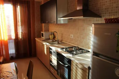 a kitchen with a stove and a refrigerator at Ideal Residence & SPA in Alcamo