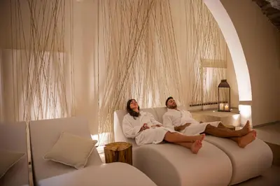 two women sitting on a couch in a living room at Costamante Suites & Spa in Castellammare del Golfo