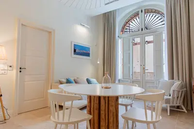 a room with a table and chairs and a window at Costamante Suites & Spa in Castellammare del Golfo