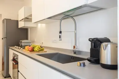 a kitchen with a sink and a bowl of fruit on the counter at Politeama rooftop in Palermo