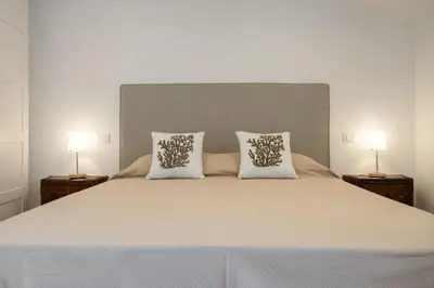 a bedroom with a large bed with two lamps at Politeama rooftop in Palermo