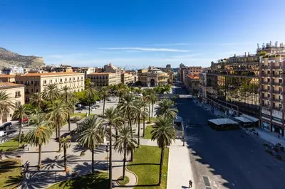 a city with palm trees and a street at Politeama rooftop in Palermo