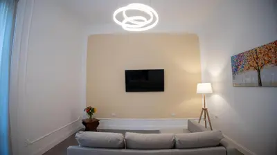 a living room with a couch and a tv at Petrarca Suite in Palermo