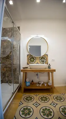 a bathroom with a mirror and a table and a shower at Petrarca Suite in Palermo