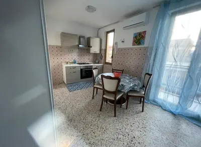 a kitchen and dining room with a table and chairs at Appartamento Ponente in Balestrate