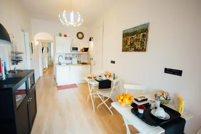 a kitchen and living room with a table and chairs at Bed à Cala in Palermo