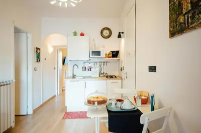 a kitchen with white cabinets and a table with a cake on it at Bed à Cala in Palermo