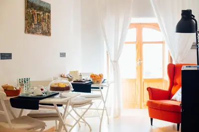 a living room with a table and chairs and a window at Bed à Cala in Palermo