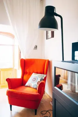 a red chair with a pillow in a room at Bed à Cala in Palermo