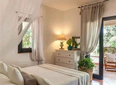 a bedroom with a bed and a dresser and a window at Cala Bianca (The One&Only) in Castellammare del Golfo