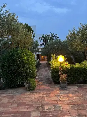 a brick walkway with a light in a garden at Cala Bianca (The One&Only) in Castellammare del Golfo