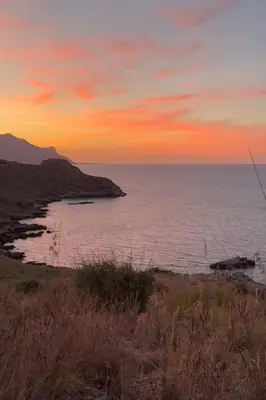 a sunset over a body of water with the ocean at Cala Bianca (The One&Only) in Castellammare del Golfo