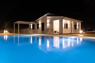a swimming pool in front of a house at night at Villa Balata mare e relax in Balata di Baida