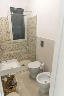 a bathroom with a toilet and a sink and a mirror at Villa Balata mare e relax in Balata di Baida