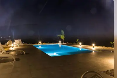 a swimming pool at night with chairs and lights at Villa Balata mare e relax in Balata di Baida