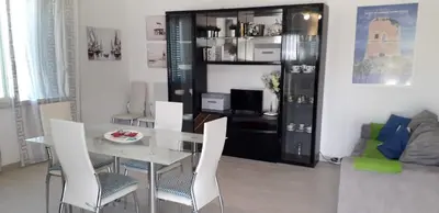 a dining room with a table and white chairs at La Casa sul Mare in Balestrate
