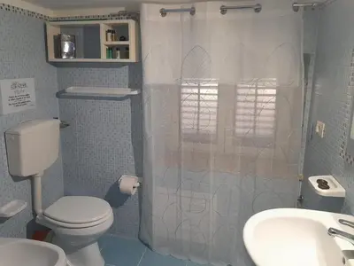 a bathroom with a toilet and a shower and a sink at Casa TerraMare in Palermo